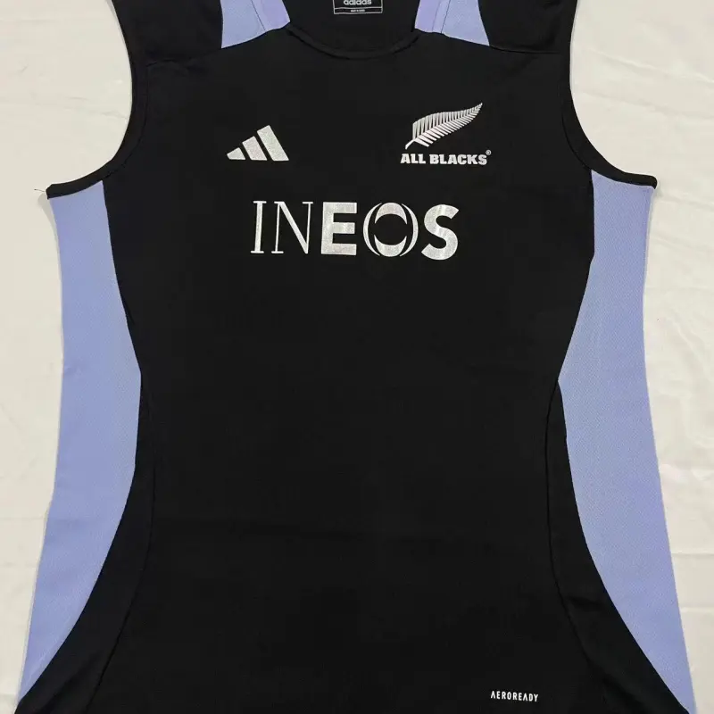 Maglia Nuova Zelanda All Blacks 2024 nera con pannelli laterali azzurri senza maniche.