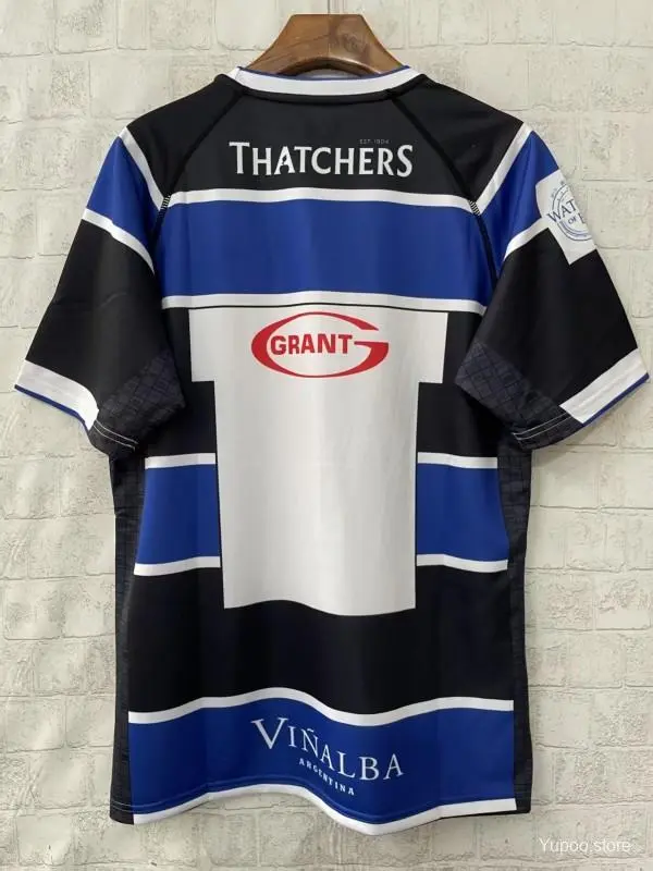 Maglia Bath Rugby 25/26 blu con cerchi bianchi e neri.
