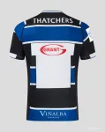 Maglia Bath Rugby 25/26 blu con cerchi bianchi e neri.