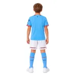 22/23 Manchester City Home Kids Kit — AI model preview, full-body back view; socks optional